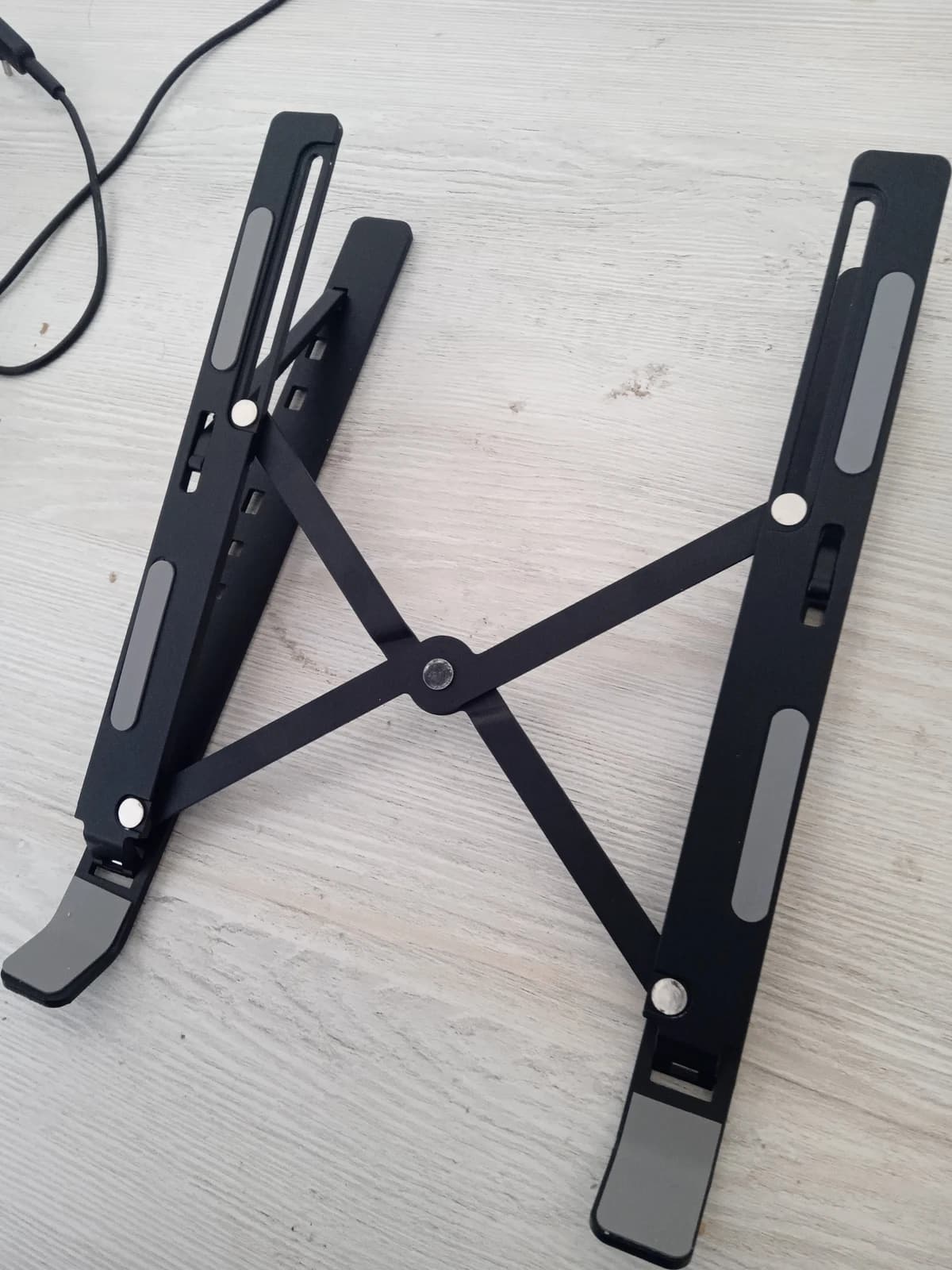 Suporte dobrável preto; fabricante/modelo não identificados